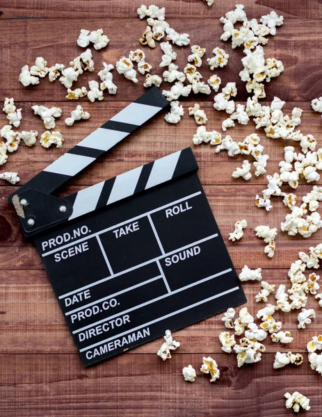vintage classic clapperboard and popcorn on brown wooden table