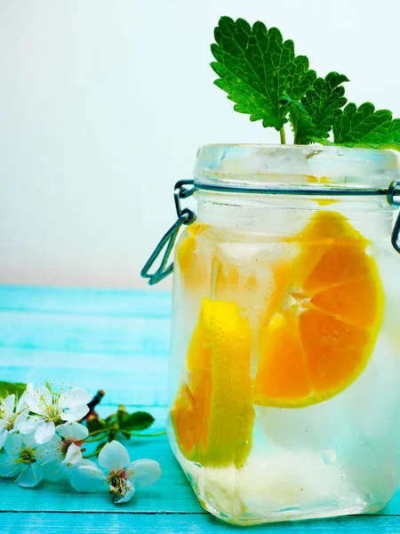 Agua con mandarín, menta y florecitas sobre fondo de madera. Enfoque selectivo —  Fotos de Stock