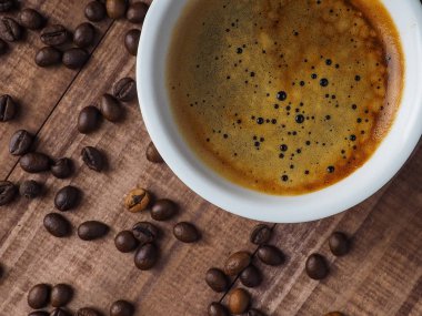 kahve fincanı ve masada kahve çekirdekleri