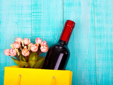 -bir şişe şarap ve paket üzerinde ahşap arka plan, metin için yer çiçek