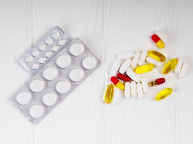 çok fazla hap üzerinde beyaz ahşap arka plan, metin, tıp ve sağlık kavramı için kopya alanı