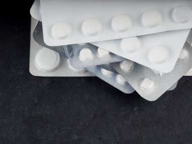 siyah bir zemin üzerine bir blister içinde birçok tablet metin için yer kopyalayın