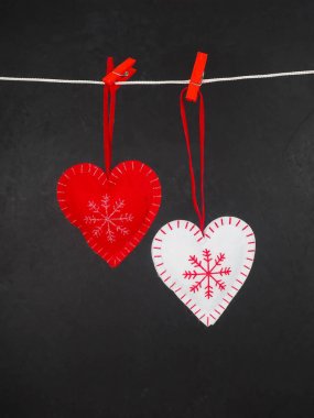 Noel süslemeleri, clothespin siyah bir arka plan üzerinde kırmızı ve beyaz Kalpler