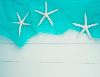 Deniz kabuğu denizyıldızı turkuaz bezle beyaz ahşap zemin üzerinde. nazik arka plan, arka plan yaz Tema. kopya alanı