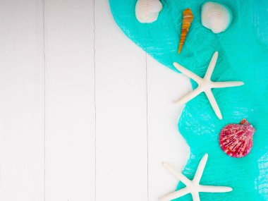 Deniz kabuğu denizyıldızı turkuaz bezle beyaz ahşap zemin üzerinde. nazik arka plan, arka plan yaz Tema. kopya alanı