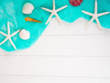 Deniz kabuğu denizyıldızı turkuaz bezle beyaz ahşap zemin üzerinde. nazik arka plan, arka plan yaz Tema. kopya alanı