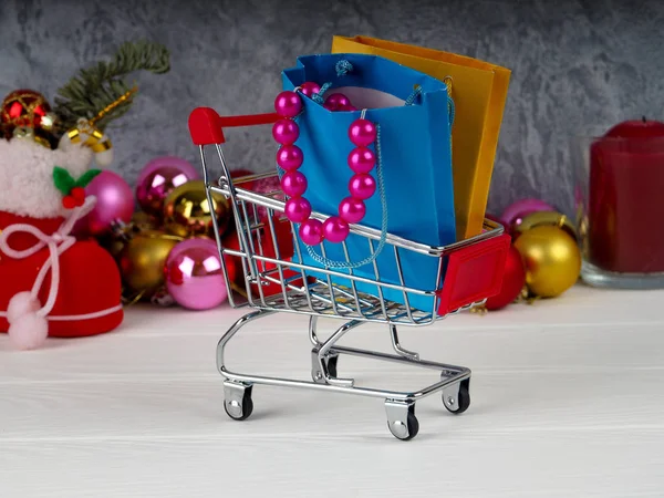 Kerstmis korting, beetje winkelmandje vol met giften van Kerstmis, winkelwagentje met geschenkdozen — Stockfoto