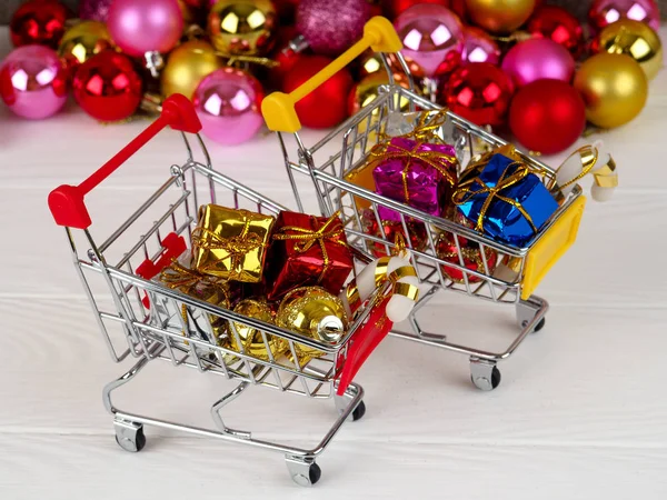 Χριστούγεννα έκπτωση, μικρό καλάθι γεμάτο δώρα Χριστουγέννων, ψώνια άμαξα με κουτιά δώρων — Φωτογραφία Αρχείου