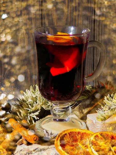 Vin chaud de Noël avec des épices en verre avec plaid et neige sur un arbre de Noël sur fond sombre, La tasse en verre de boisson chaude d'hiver — Photo