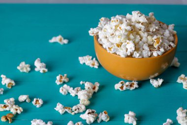 Mavi ahşap zemin üzerine kase patlamış mısır