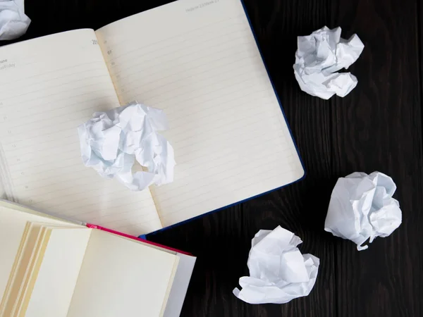 Almohadilla blanca sobre una mesa de madera. Concepto de escritura - trozos de papel arrugados con Bloc de notas — Foto de Stock