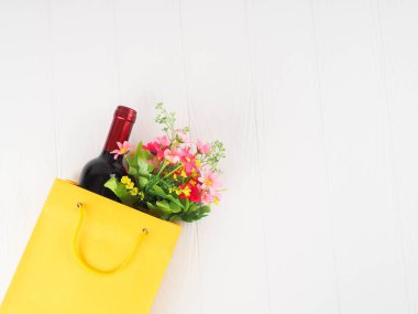 -bir şişe şarap ve paket üzerinde ahşap arka plan, metin için yer çiçek