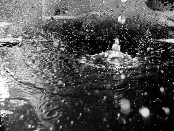 Einen Tropfen Wasser spritzen, farbloses Wasserspray schließen, dunkler Ton — Stockfoto