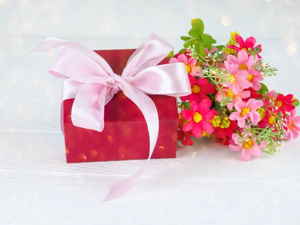 Kleine geschenkverpakking versierd met lint en bloem, mooie romantische gift box op hout — Stockfoto