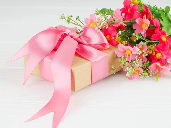 Kleine geschenkverpakking versierd met lint en bloem, mooie romantische gift box op hout — Stockfoto