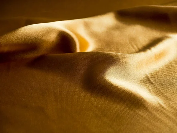 Gold luxury satin fabric texture for background, Smooth elegant dark gold satin. background for Christmas cards, gold trend