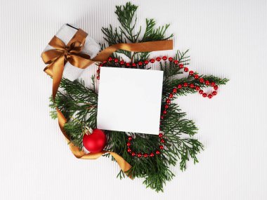Noel tatili arkaplanı ve metin için fotokopi alanı. Düz yerde, üst tarafta. Köknar dalları ve kırmızı boncuklardan oluşan dekoratif bir çerçeve. Kağıt uyarı sayfası