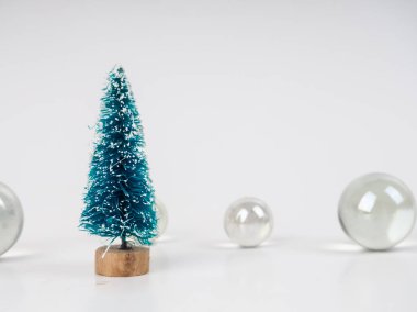 Şeffaf topların arka planında küçük bir oyuncak Noel ağacı, yeni yıl ve Noel için minimalist kart
