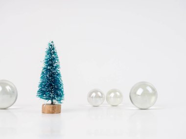 Şeffaf topların arka planında küçük bir oyuncak Noel ağacı, yeni yıl ve Noel için minimalist kart