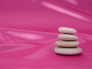 Güzel, pembe bir arka planda taş yığını. Sakin, gevşemiş, yavaş, tembel. Boşluğu kopyala.