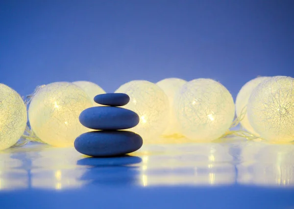 Stack of Zen stones on abstract dark background of Christmas gar