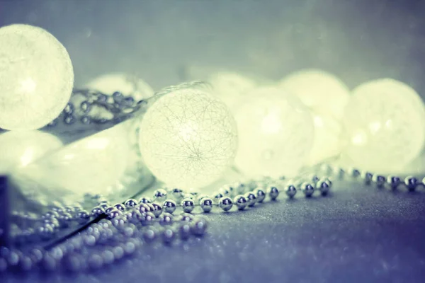 Heldere slinger in de vorm van ballen gloeit op een zilveren sprankelende — Stockfoto