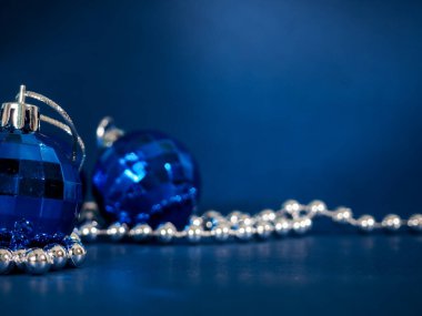 Gümüş boncuklu mavi Noel balosu. Koyu arkaplanda Bokeh etkisi. Selamlamanız ya da istekleriniz için kopyalanma alanı, pankart