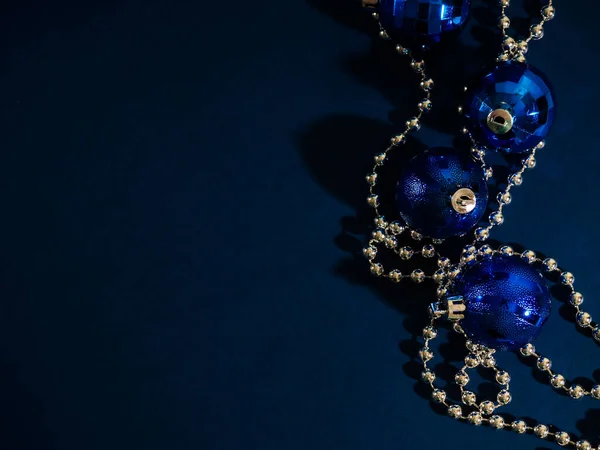 Blauwe kerstbal met zilveren kralen. Bokeh effect op donkere achtergrond. Kopieerruimte voor uw groet of wensen, banner — Stockfoto