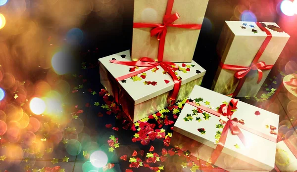 Dobozok karácsonyi ajándékokat kötött piros szalaggal egy sötét backgr — Stock Fotó