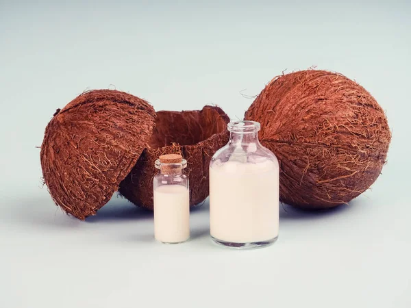 Leite de coco e coco na mesa azul. Óleo de coco com n fresco — Fotografia de Stock