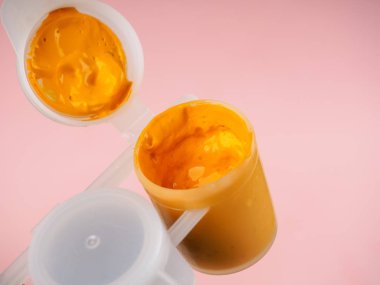 Gouache boyalı renkli şişe, yakın plan. Sarı şişe ve guaj boyası.