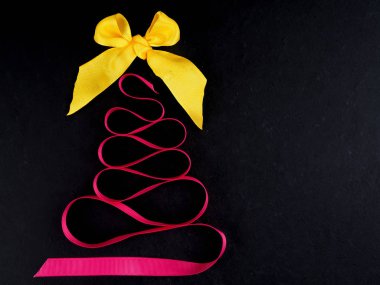 Pembe kurdeleden yapılmış köknar ağacıyla yassı yatak, Noel zamanı konsepti. Pembe kurdeleden yapılmış Noel ağacı. Düz yatak, tatil zamanı kavramı.