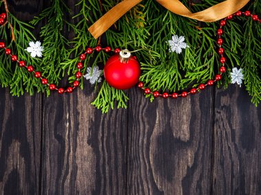 Tahta arka planda Noel süsü olan firavun ağacı dalları. Mesaj için yer var. Tahta arka planda Noel süslemeleri olan fidan dalları, düz uzanmış