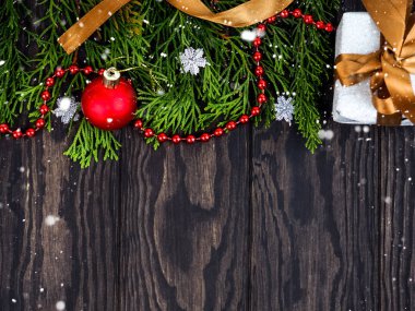 Tahta arka planda Noel süsü olan firavun ağacı dalları. Mesaj için yer var. Tahta arka planda Noel süslemeleri olan fidan dalları, düz uzanmış