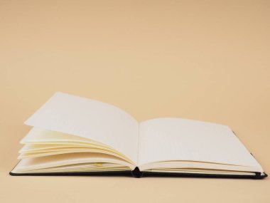 Bej arkaplan çalışma alanı üzerine not defteri aç. Açık not defterinin maketi