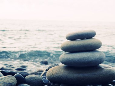 Denge, huzur, farklı boyutlarda taşlar piramit oluşturur çakıl taşı plajında taş piramit dengeyi, zen, uyum ve dengeyi sembolize eder. Sığ alan derinliği
