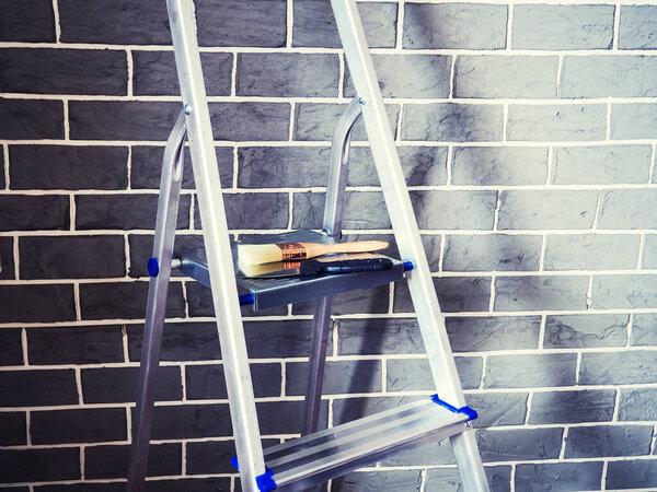 Finishing work in a newly built house, Step ladder and decorator s tools near wall repair tools.