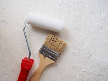 Boya işi için bir araç. Spatula ve fırça. Tamir edilecek eşyalar. Tahtaya macun sürmek için fırça ve spatula kullanan bir müteahhit. Reklam için boş yer, metin. Otantik fotoğraf, macunu onardıktan sonra gerçek fırça, gerçek tamir görüntüsü.