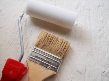 Boya işi için bir araç. Spatula ve fırça. Tamir edilecek eşyalar. Tahtaya macun sürmek için fırça ve spatula kullanan bir müteahhit. Reklam için boş yer, metin. Otantik fotoğraf, macunu onardıktan sonra gerçek fırça, gerçek tamir görüntüsü.