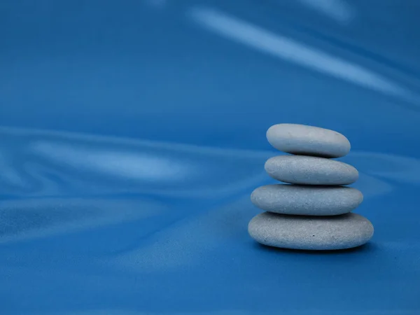 Stack of Zen stones on abstract blue classic color background of garlands. Relax still Life with folded stones. Zen pebbles, stones, Spa-calm scenes slow life the soul of the imperturbable tranquility.