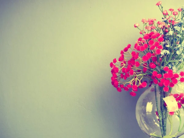 artificial flowers transparent vase. Closeup artificial colorful flower on transparent glass bottle.