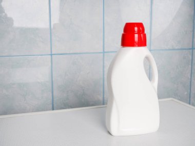 Çamaşır makinesinde bir şişe deterjan ve temiz havlu, mesaj için yer. Çamaşır günü.