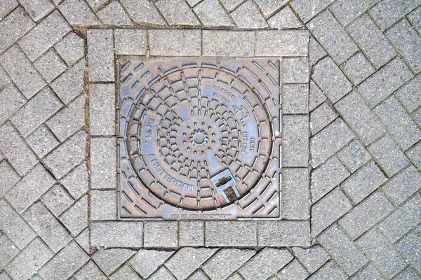 Tapa de alcantarilla en pavimento con motivos, Amsterdam — Foto de Stock