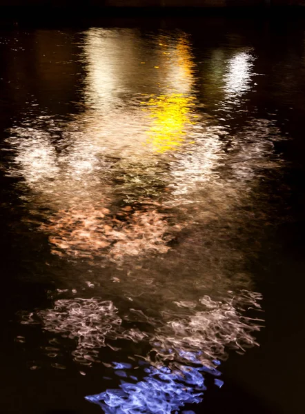 Riflessione di luce di notte in acqua nella forma della gente — Foto Stock