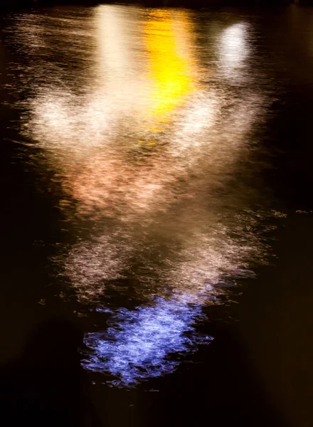 Riflessione di luce di notte in acqua nella forma della gente — Foto Stock