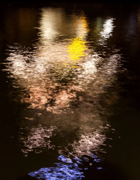 Riflessione di luce di notte in acqua nella forma della gente — Foto Stock