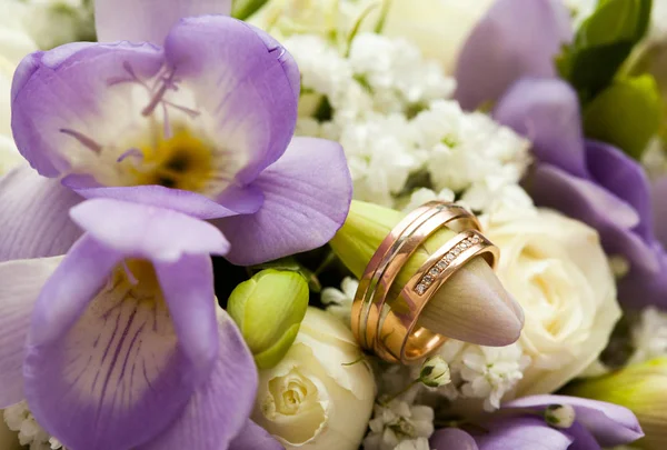 A composição do buquê e anéis de casamento de perto — Fotografia de Stock