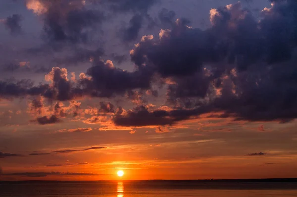 Pôr-do-sol colorido de um dia nublado no mar — Fotografia de Stock