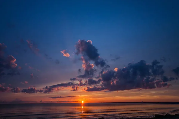 Pôr-do-sol colorido de um dia nublado no mar — Fotografia de Stock