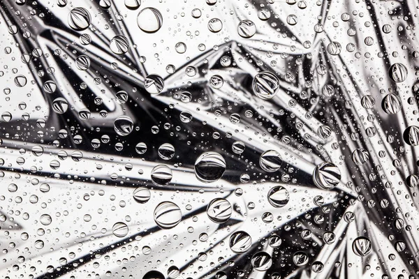 Abstrakta linjer genom droppar vatten på ett glas — Stockfoto